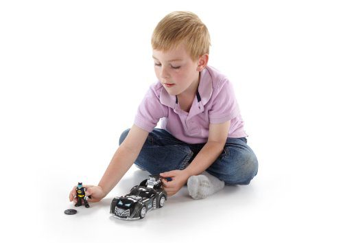 Young boy playing with superhero car toy, showcasing creativity and imaginative storytelling.