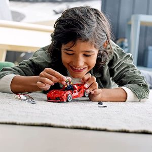 Joyful child immersed in imaginative play with a red toy car on a cozy rug.