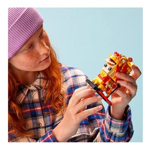 Young builder with red hair admires colorful Lego figure against a serene blue background.