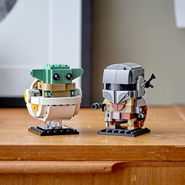 LEGO display featuring The Child and Mandalorian figures on a cozy wooden surface.