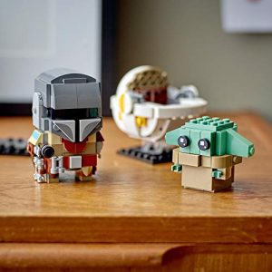 LEGO Mandalorian and The Child figures create a vibrant, whimsical adventure on a wooden table.